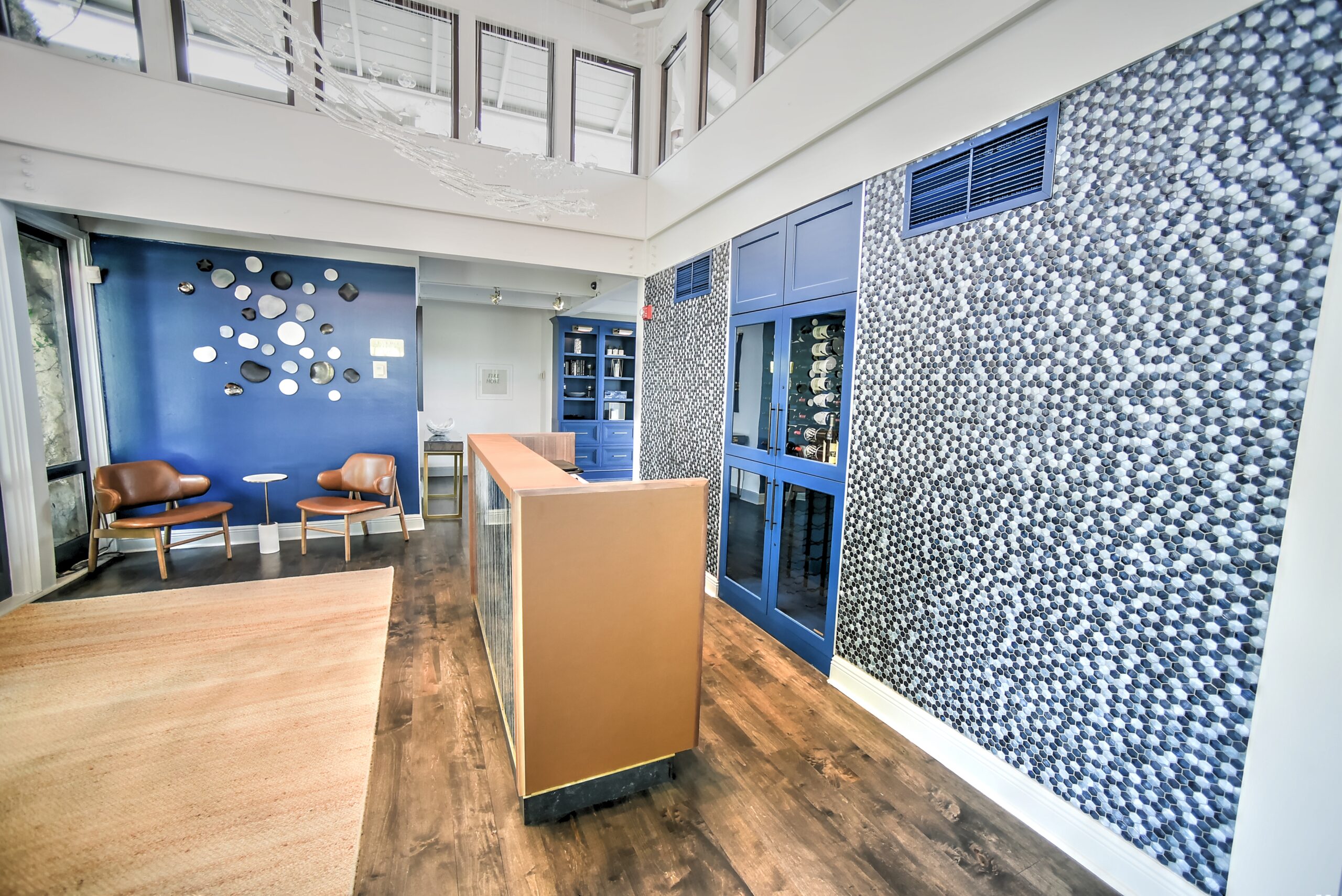 This image shows a hotel that Riken Construction remodeled. There is brand-new wooden floors, a new desk for hosting, and brand new tile/backsplash to accent their blue walls.